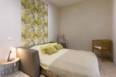a bedroom with a bed and a painting on the wall at 13 Boulevard Carnot by Halldis in Cannes