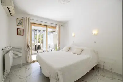 a white bedroom with a bed and a window at REF 1966 - Cannes city center in Cannes