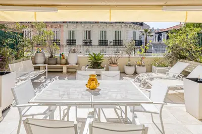 a white table and chairs on a patio with a building at REF 1966 - Cannes city center in Cannes