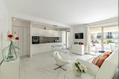 a living room with white furniture and a kitchen at REF 1966 - Cannes city center in Cannes