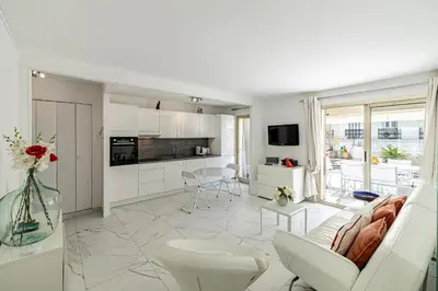 a white living room with a white couch and a kitchen at REF 1966 - Cannes city center in Cannes