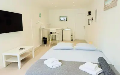 a white room with a bed and a flat screen tv at Aura Apartments by Halldis in Cannes
