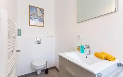 a white bathroom with a sink and a toilet at Aura Apartments by Halldis in Cannes