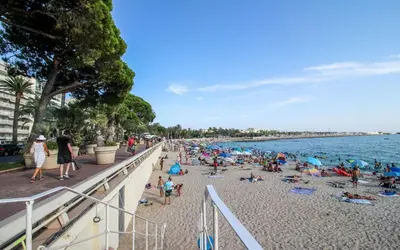 a crowd of people on a beach near the water at Aura Apartments by Halldis in Cannes