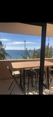 a table and chairs on a balcony with a view of the ocean at Charme in Cannes La Bocca