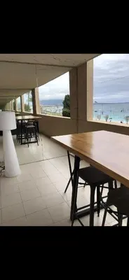 a dining room with a table and a view of the beach at Charme in Cannes La Bocca