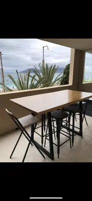 a wooden table and chairs in front of a window at Charme in Cannes La Bocca