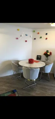 a table and chairs in a room with a white wall at Charme in Cannes La Bocca