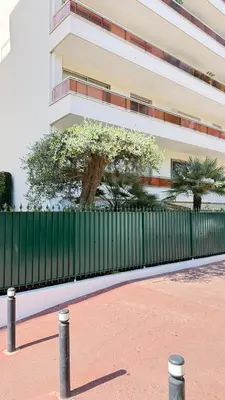a green fence in front of a building at Studio basse californie cannes in Cannes