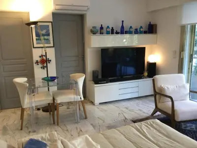 a living room with a glass table and a tv at Studio basse californie cannes in Cannes