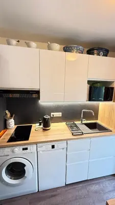 a kitchen with white cabinets and a washing machine at Studio basse californie cannes in Cannes