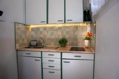 a kitchen with white cabinets and a sink at Very Quiet Palm Beach Studio Close Beach in Cannes
