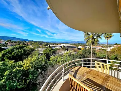 a balcony with a wooden bench and a view at T2 Vue dégagée proche Cannes in Le Cannet