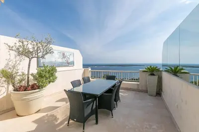 a balcony with a table and chairs and the ocean at REF 1969 - Cannes - Penthouse with panoramic sea view for rent in Cannes