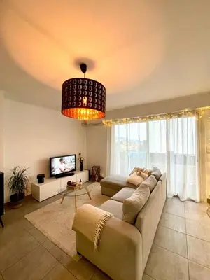 a living room with a couch and a tv at Bel Appartement lumineux avec balcon in Le Cannet