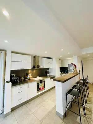 a kitchen and living room with a table and chairs at Bel Appartement lumineux avec balcon in Le Cannet