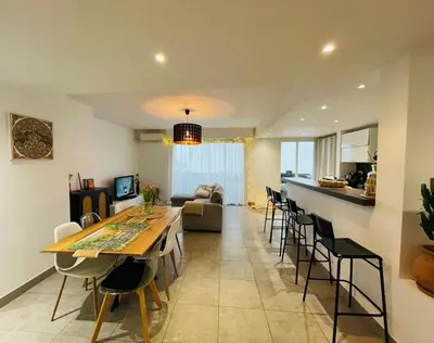 a kitchen and a living room with a couch and a table at Bel Appartement lumineux avec balcon in Le Cannet