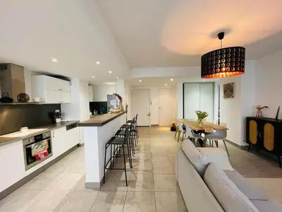 a living room with a table and a couch at Bel Appartement lumineux avec balcon in Le Cannet