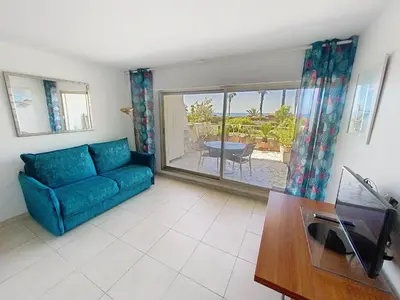 a living room with a blue couch and a table at Superbes prestations grande terrasse 352L in Cannes
