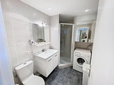 a bathroom with a toilet sink and a washing machine at Superbes prestations grande terrasse 352L in Cannes