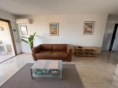 a living room with a couch and a coffee table at Appartement vue & front de mer, piscines, 55M2 2Pièces in Cannes