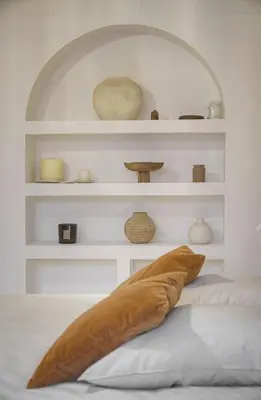 a pillow on a bed in a room with shelves at Le Trendee - Loft atypique in Cannes