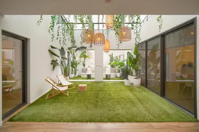 a living room with a green rug and plants at Le Trendee - Loft atypique in Cannes