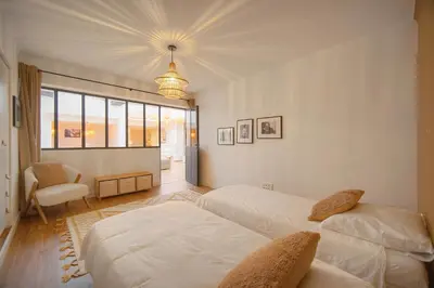 a bedroom with two beds and a chair at Le Trendee - Loft atypique in Cannes