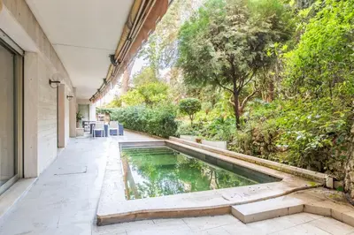a pool in the middle of a courtyard with trees at Appartement en bord de mer avec piscine - Cannes in Cannes