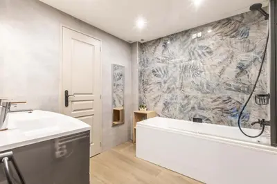 a bathroom with a bath tub and a sink at Appartement en bord de mer avec piscine - Cannes in Cannes
