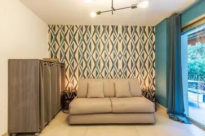 a living room with a couch and a wall at Appartement en bord de mer avec piscine - Cannes in Cannes