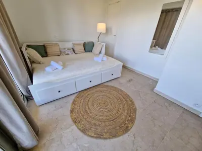 a white bed in a room with a rug at Studio Le Floriana-2 by Interhome in Cannes