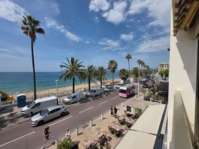 a city street with cars parked on the beach at Apartment Le Panoramer by Interhome in Cannes