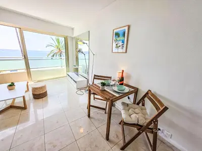 a living room with a table and chairs and the ocean at Apartment Le Panoramer by Interhome in Cannes