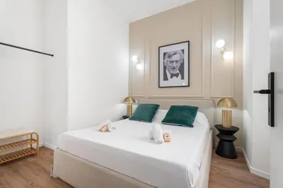 a bedroom with a large white bed with green pillows at Appartement Montrose - Welkeys in Cannes