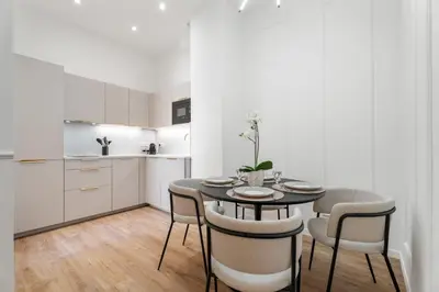 a kitchen and dining room with a table and chairs at Appartement Montrose - Welkeys in Cannes