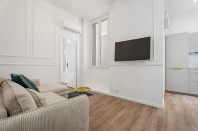 a living room with a couch and a flat screen tv at Appartement Montrose - Welkeys in Cannes