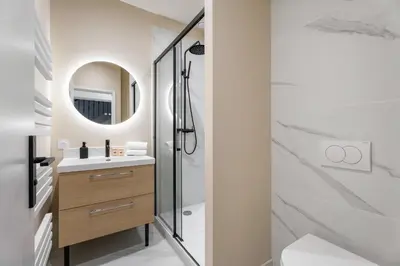 a bathroom with a shower and a sink and a mirror at Appartement Montrose - Welkeys in Cannes
