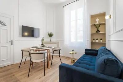 a living room with a blue couch and a table at Appartement Prado - Welkeys in Cannes