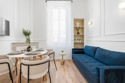 a living room with a blue couch and a table at Appartement Prado - Welkeys in Cannes