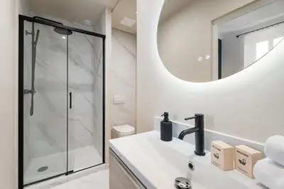 a bathroom with a shower and a sink with a mirror at Appartement Prado - Welkeys in Cannes