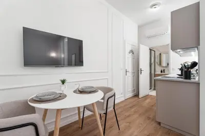 a living room with a table and chairs and a kitchen at Studio Bella - Welkeys in Cannes