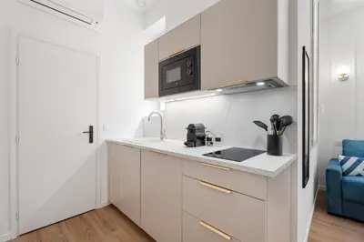 a white kitchen with a sink and a microwave at Studio Bella - Welkeys in Cannes