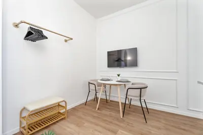 a white room with a table and chairs and a tv at Studio Bella - Welkeys in Cannes