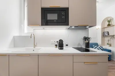 a white kitchen with a sink and a microwave at Studio Bella - Welkeys in Cannes