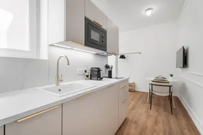 a white kitchen with a sink and a microwave at Studio Bella - Welkeys in Cannes