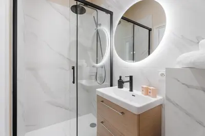 a bathroom with a shower and a sink and a mirror at Studio Bella - Welkeys in Cannes