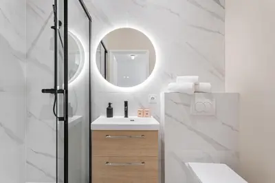 a bathroom with a sink and a mirror at Studio Bella - Welkeys in Cannes
