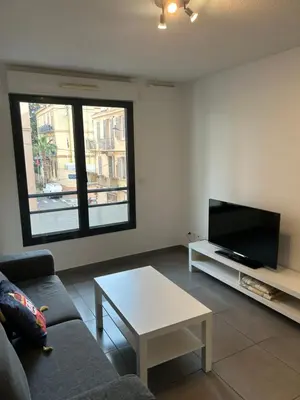 a living room with a couch and a tv and a table at studio confortable in Cannes