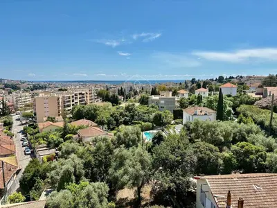 a view of a city with trees and buildings at Le Beauséjour, studio with pool, parking, air conditioning in Le Cannet
